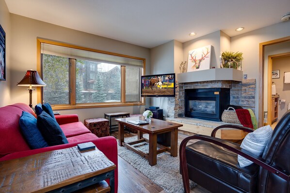 A cozy living room with a fireplace, a television, and comfortable seating. - TR1104 | Updated Corner Unit | Winter Shuttle | 10 Hot Tubs | Close to Skiing (Steamboat Springs)
