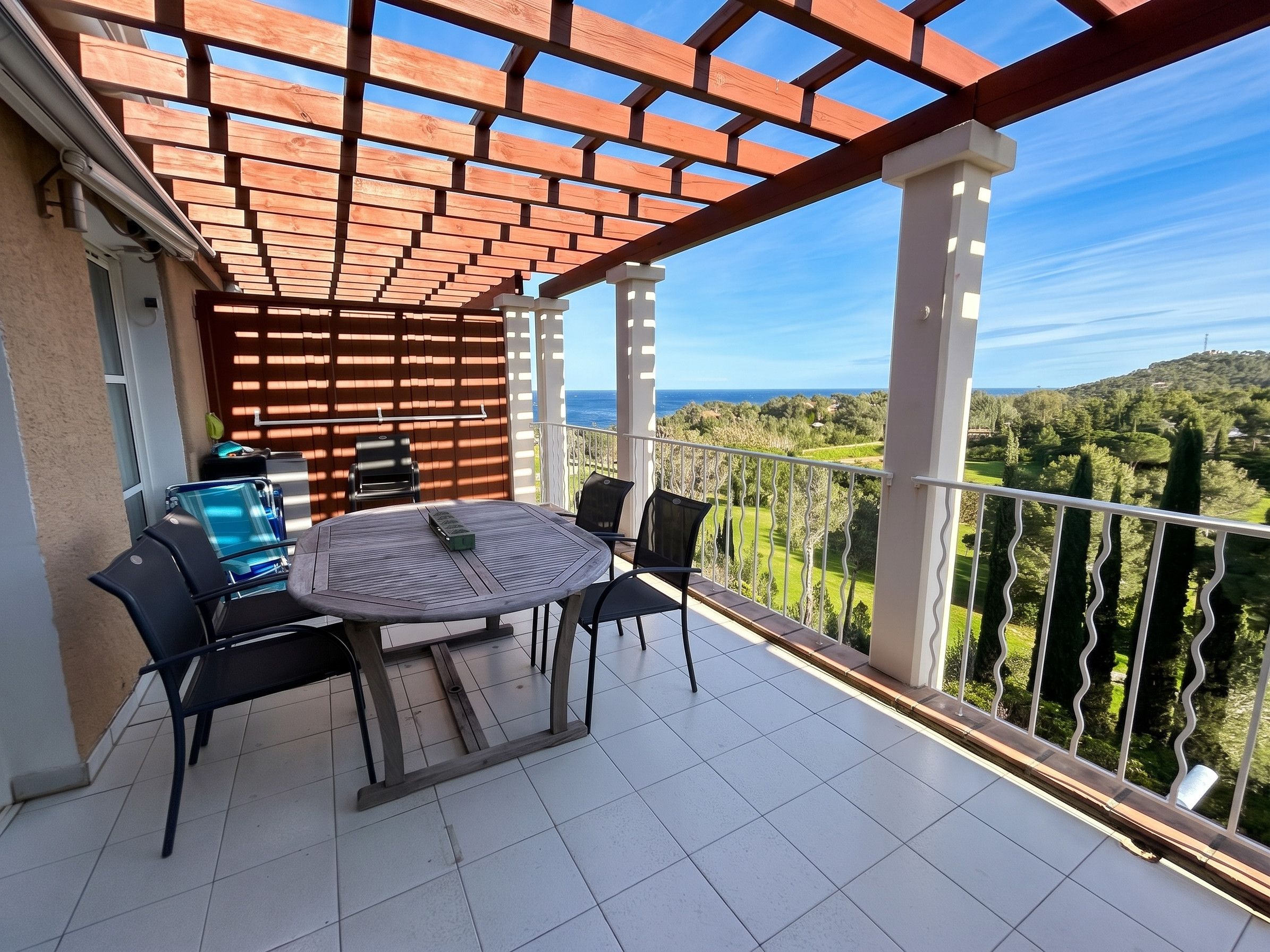 Een balkon met een tafel en stoelen, met uitzicht op een prachtig landschap.