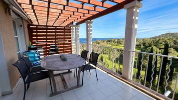 Een balkon met een tafel en stoelen, met uitzicht op een prachtig landschap.