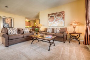 A living room with two sofas, a coffee table, and a lamp. - Spacious 3BR Condo near Convention & Theme Parks (Orlando)