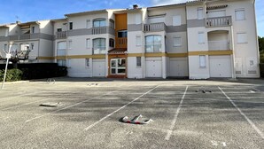 A multi-story residential building with a central entrance, balconies, and a parking lot in front. - Cozy Studio Near Beach, Shops, Private Garage, Pet-Friendly, Sleeps 4 (Argelès-sur-Mer)