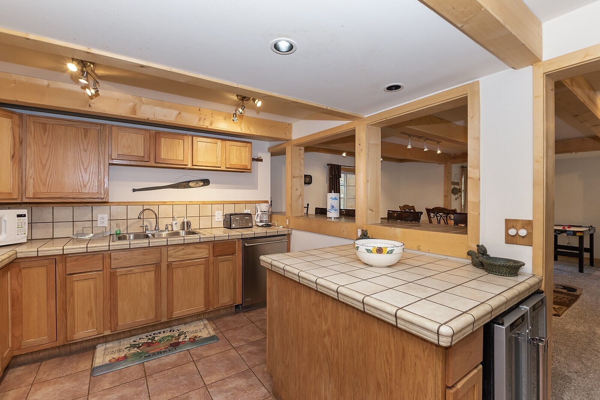 A modern kitchen with wooden cabinets, a tiled backsplash, and a central island.