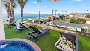 A rooftop pool area with lounge chairs and a hot tub, overlooking a coastal town. - Beach View Pet Friendly Home with a Spa Pe-1722 (Oceanside)