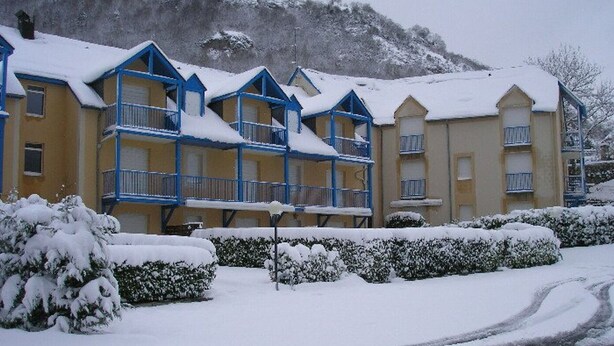 A hotel with multiple floors, balconies, and a snowy landscape. - Calm T3 for 6, terrace, garden, near amenities (Esquièze-Sère)