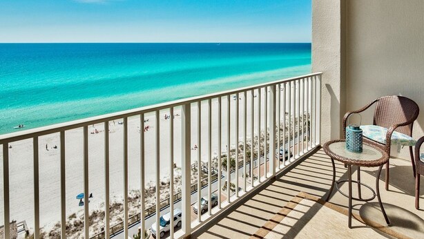 Un balcon avec vue sur une plage et l’océan.