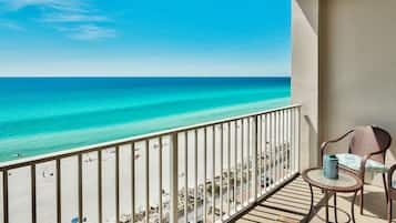Een balkon met uitzicht op strand en zee.