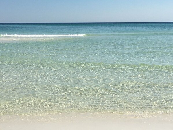 Een strand met helder ondiep water en een zandstrand.