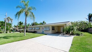 A single-story building with a flat roof, a front porch, and a paved driveway.