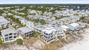 Un quartier résidentiel situé sur la côte, avec des propriétés en bord de mer, notamment des maisons dotées de balcons et d’une piscine.