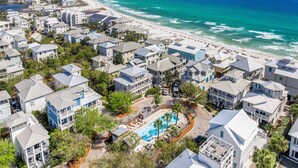 Un quartier résidentiel situé sur la côte, avec des propriétés donnant sur la plage, une piscine et une plage.