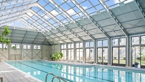 An indoor swimming pool with a glass ceiling, clear windows, and a tiled floor. - Gulf View: Crown Studio on Main St, across from Pearl Hotel (Rosemary Beach)