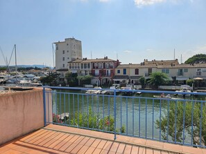 Un balcón con vistas a un puerto deportivo, barcos y edificios.