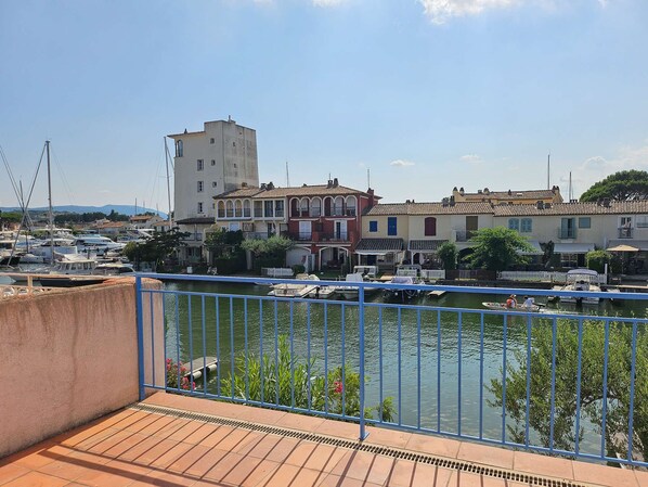 Un balcón con vistas a un puerto deportivo, barcos y edificios.