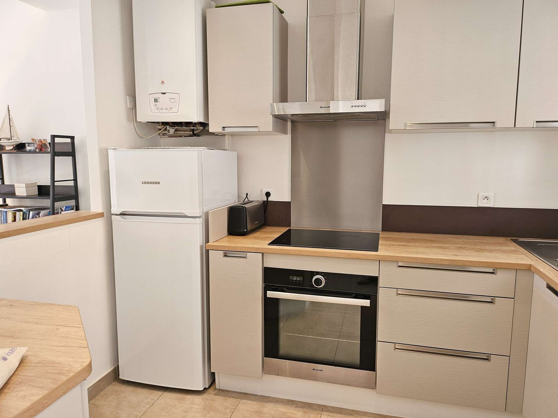 A compact kitchen with a built-in oven, a dishwasher, and a refrigerator.