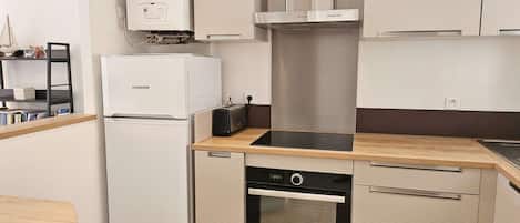 A compact kitchen with a built-in oven, a dishwasher, and a refrigerator.