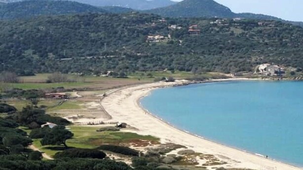 A coastal landscape with a curved bay, a sandy beach, and a backdrop of green hills. - Homerez - Flat in Feliceto (Feliceto)
