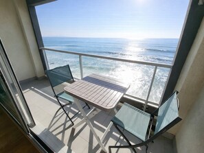 A balcony with a table and two chairs, overlooking the ocean. - Studio with balcony, WIFI, and parking near the beach (Les Sables-d'Olonne)