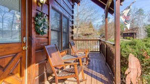Eine Holz-Blockhütte mit Veranda, zwei Schaukelstühlen und einem Kranz an der Tür.
