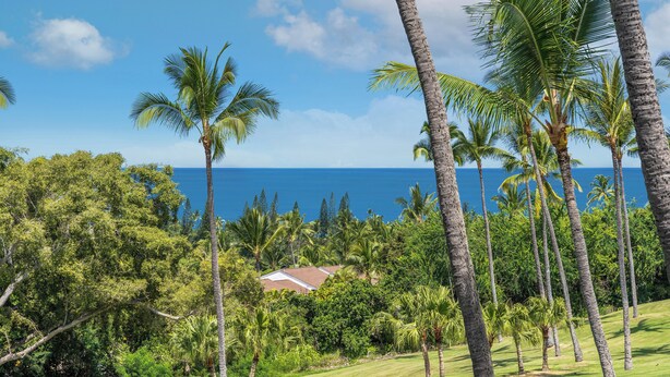 A tropical landscape with palm trees, a golf course, and a view of the ocean. - Ocean view, Country Club Villas 224, No stairs, 2nd floor unit. (Kailua-Kona)