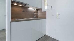 A modern kitchen with white cabinets, a stainless steel range hood, and a window above the sink. - Haven of Peace: 1-Br Terrace with Sea View & Pool (Cannes)