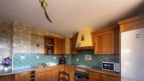 A compact kitchen with wooden cabinets, a microwave, an oven, and a refrigerator.