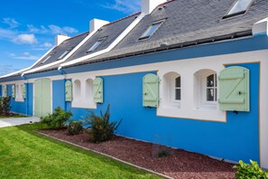 A row of houses with blue walls and green shutters, each with a small garden in front. - Homerez - House in Bangor (Bangor)