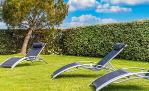 Two lounge chairs in a grassy area with a hedge and a tree in the background. - Homerez - House in Bangor (Bangor)
