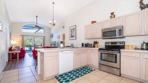 Una cocina moderna con armarios blancos, electrodomésticos de acero inoxidable y una isla grande.