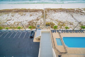 A parking lot with a pool and a beach view.