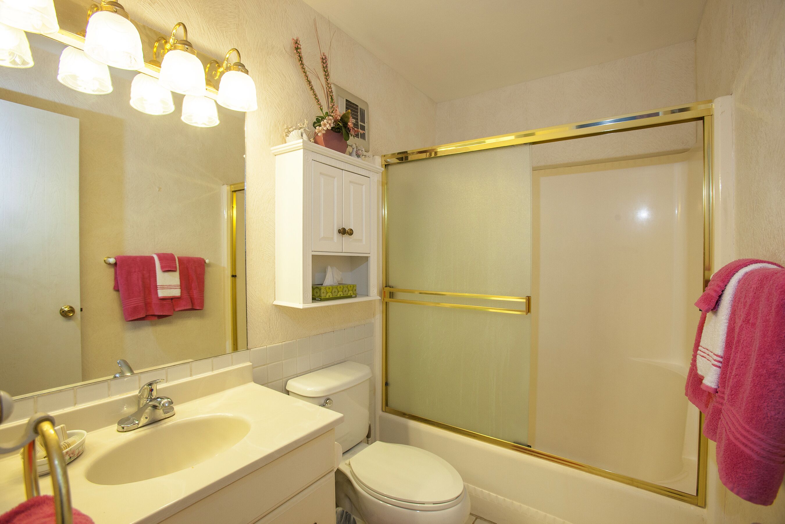 Un baño con lavamanos, inodoro y ducha.
