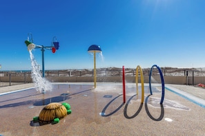 A water play area with multiple water jets and a turtle-shaped water feature.