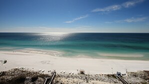 Een strand met heldere lucht, een zandstrand en een duikerspost.