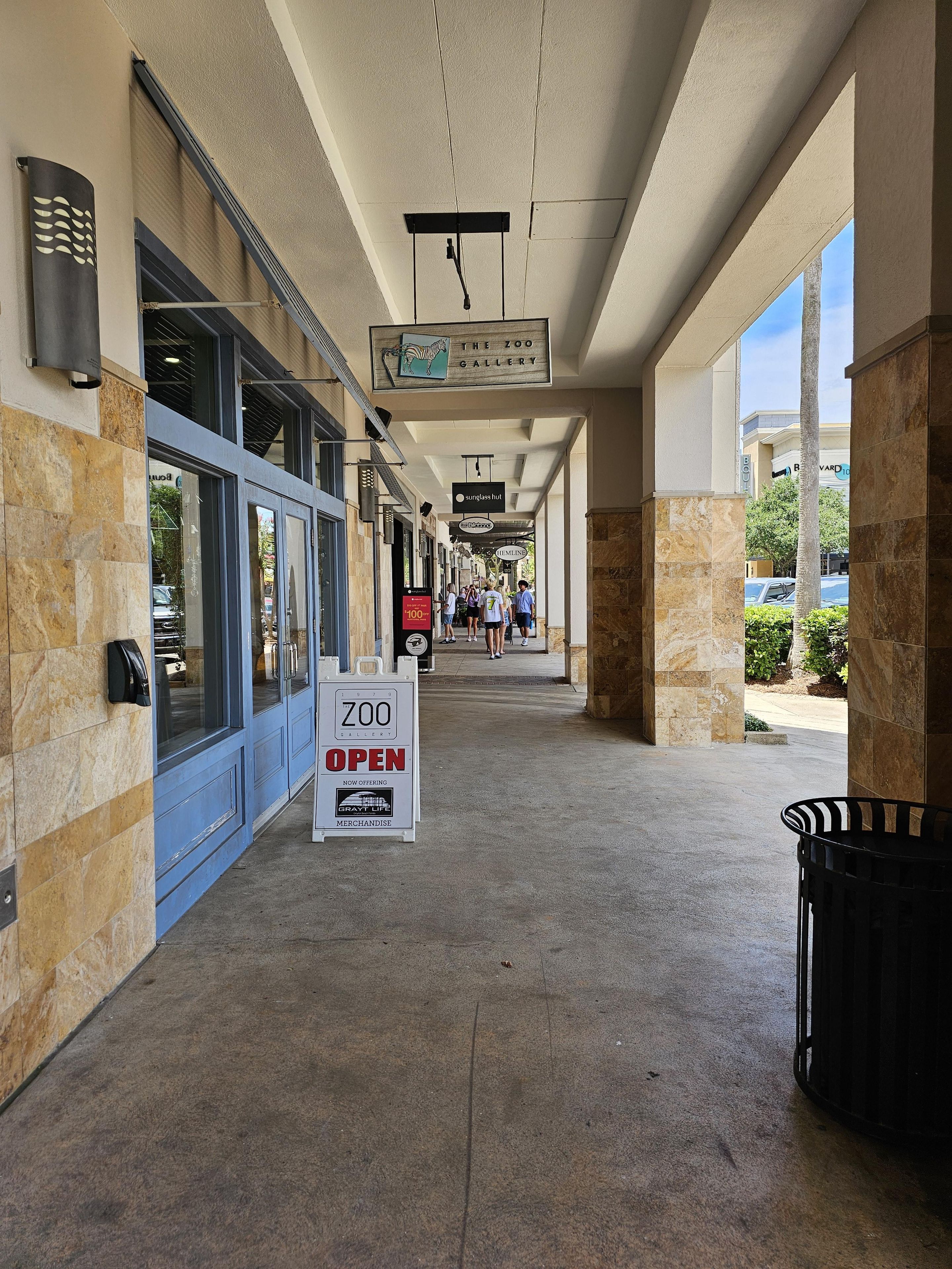 A covered walkway with a sign indicating 'The Zoo Gallery' is open, featuring a zebra logo.