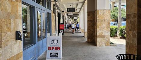 A covered walkway with a sign indicating 'The Zoo Gallery' is open, featuring a zebra logo.