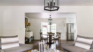 Un salon moderne avec deux canapés gris, une table basse en bois et un lustre.