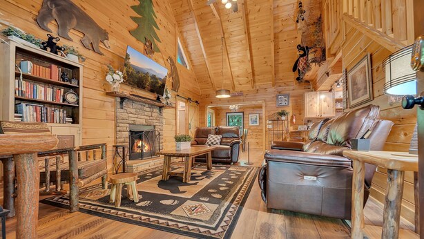 A cozy cabin interior with a fireplace, leather furniture, and wooden decor. - ER258- Sweet Memories Great location- Close to town (Pigeon Forge)