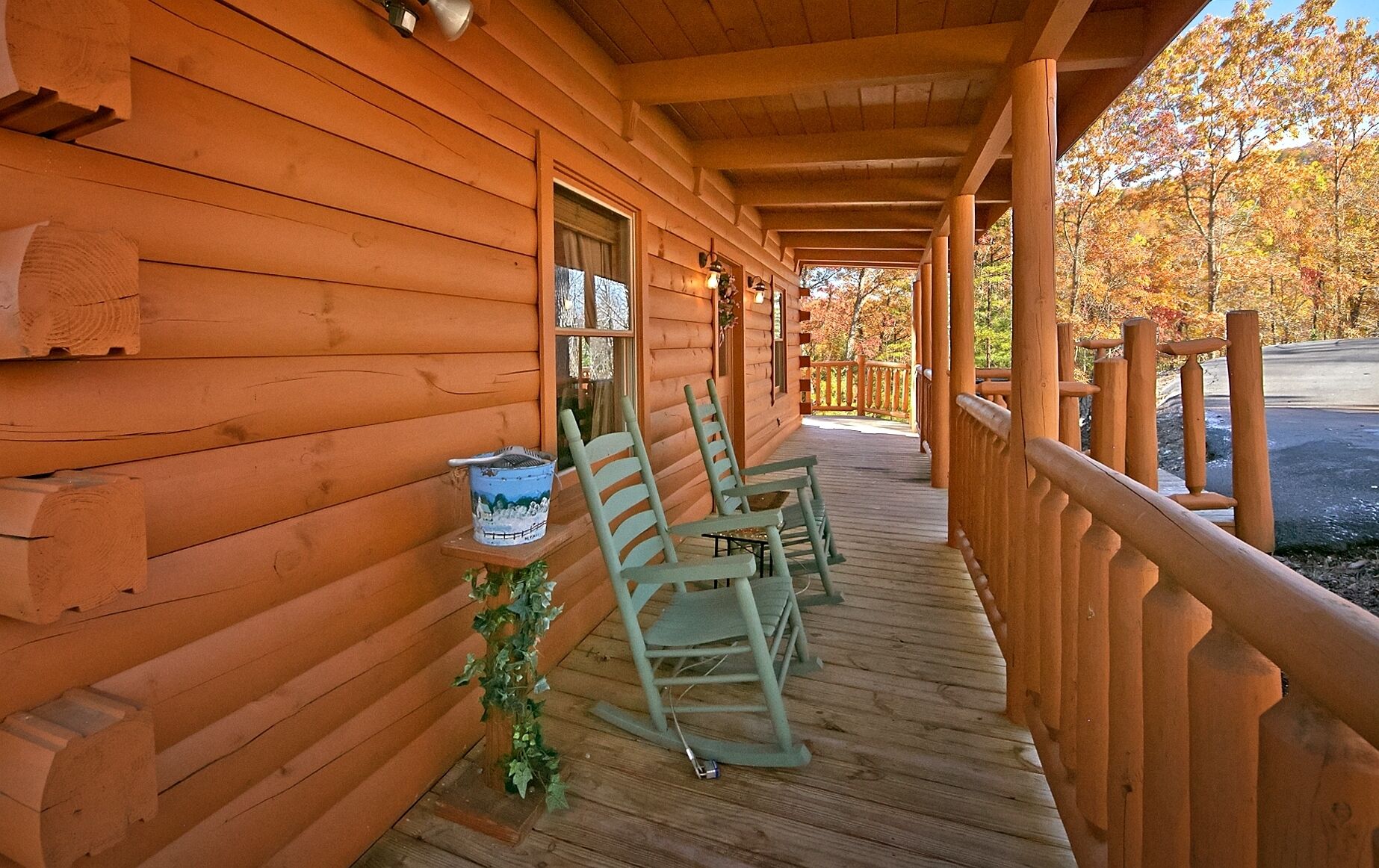 A wooden cabin with a covered porch, two rocking chairs, and a small table with a decorative item.