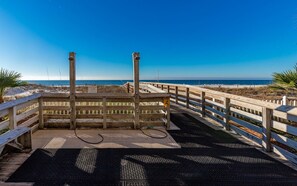 A wooden boardwalk leading to a beach with a clear view of the ocean.