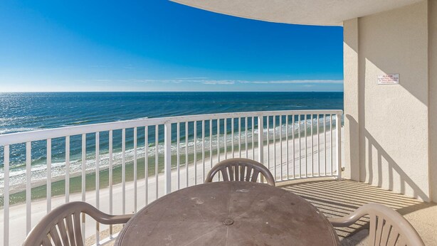 Ein Balkon mit Blick auf das Meer, einem Tisch und zwei Stühlen.