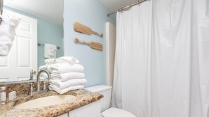 Une salle de bain équipée d’un lavabo, de toilettes et d’un rideau de douche.