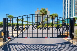 Une entrée fermée par un portail sur lequel on peut lire en lettres bien visibles : « Royal Palms ».