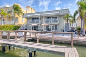 A waterfront hotel with a dock, balconies, and outdoor seating.