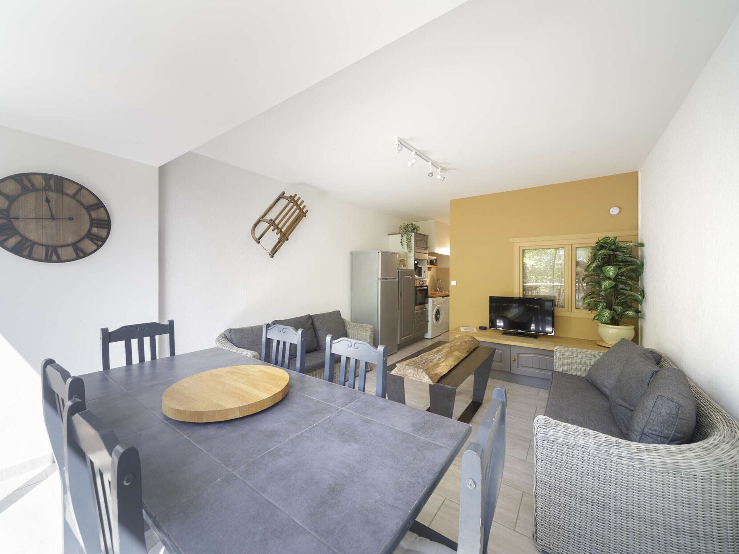 A compact living space with a dining area, kitchen, and seating area.