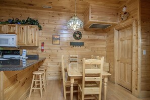 Cozy kitchen with a wooden dining table, microwave, and stainless steel stove.