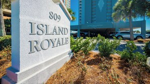 Señal que indica '809 Island Royale', con un edificio moderno al fondo.
