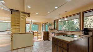 Une cuisine moderne dotée d’un îlot central, de meubles en bois et d’une cuisinière intégrée.