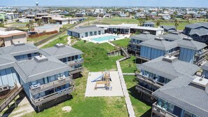 A residential area with modern houses, a swimming pool, and a playground. - Great views, swimming pool, boardwalk to the beach, picnic tables, play area, co (Port Aransas)