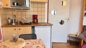Et lille køkken med mikrobølgeovn, kaffemaskine og minikøleskab.