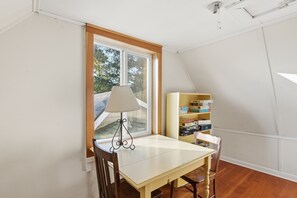 A room with a table, a lamp, and a bookshelf.