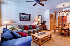 A living room with a sofa, coffee table, and a dining area with a table and chairs. - 2109 Timberline Lodge, Trappeur's Crossing Apartment 1 (Steamboat Springs)